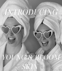 Two Estheticians wearing towels smiling with text Introducing the new Young & Bloom Skin Spa