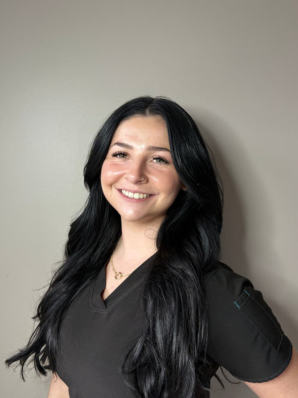 Headshot of Shannon T from Young and Bloom Skin wearing black scrubs against a white backdrop