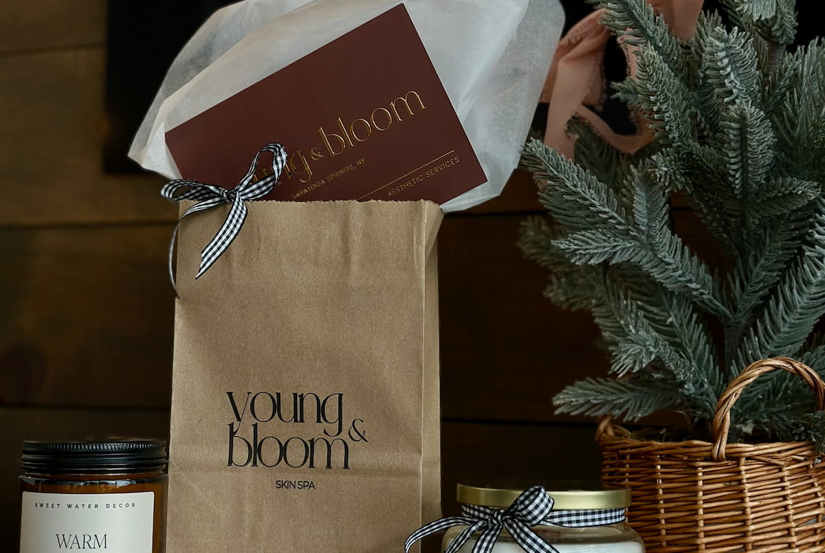 Young & Bloom branded items including a brown paper bag, jar, and plant on a wooden surface.