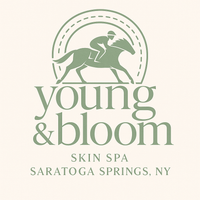 Young & Bloom Skin Spa logo featuring a jockey riding a horse framed by a stylized dashed horseshoe, with elegant serif text below reading 'Young & Bloom Skin Spa, Saratoga Springs, NY.