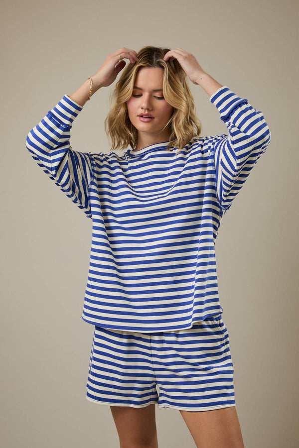 Woman wearing a blue and white striped outfit against a beige background