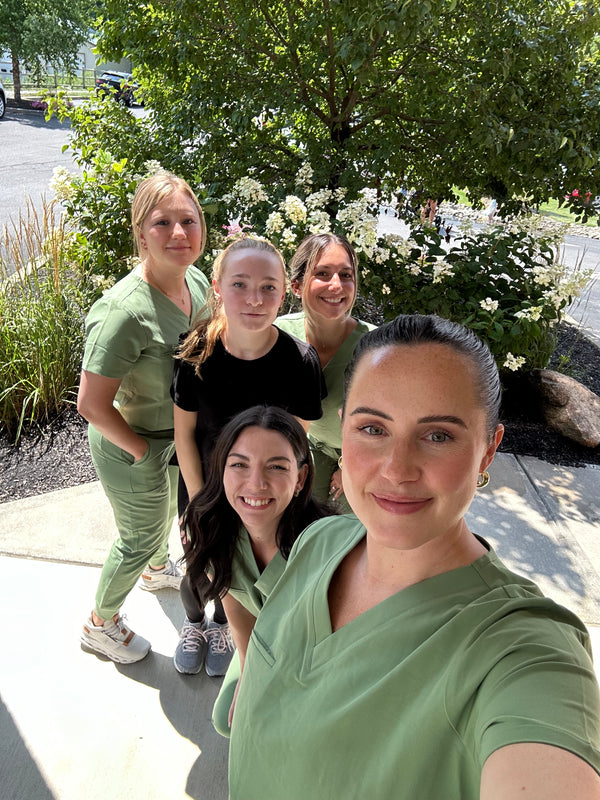 Erica Y., Owner of Young & Bloom Skin, smiling with team members at the spa in Saratoga Springs.