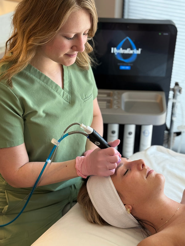 Esthetician performing a HydraFacial treatment at Young & Bloom Skin Spa in Saratoga Springs, NY