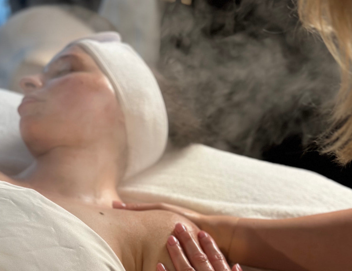 Person receiving a facial treatment with steam in a spa setting