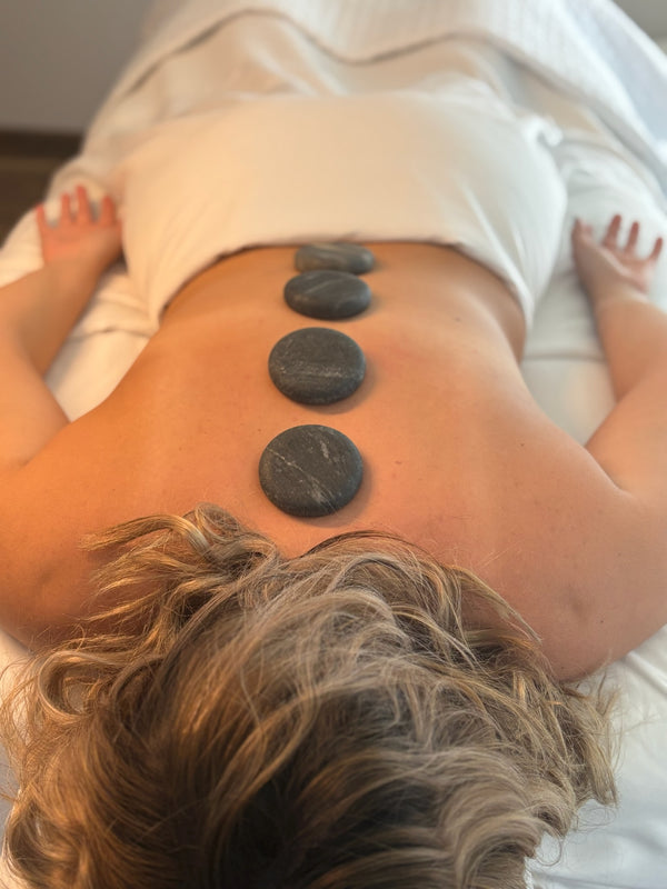 picture of a client receiving the healing touch of hot stone therapy during a massage therapy session