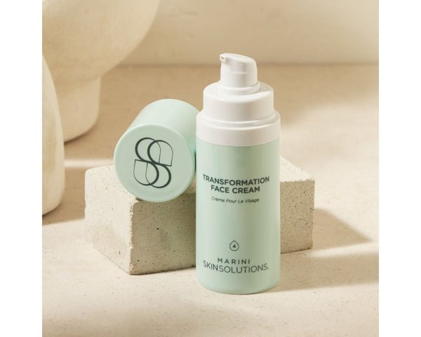 Light green face cream bottle with white cap on a beige background